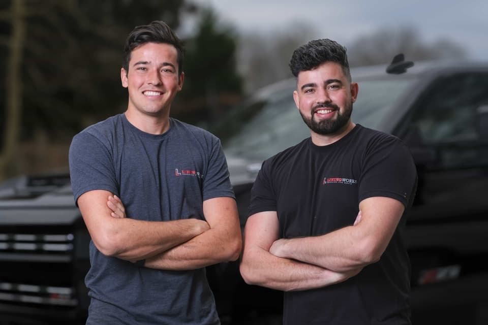 Ralph and Jeremiah Helmuth, founders of LiningWorks, in front of their service trucks.