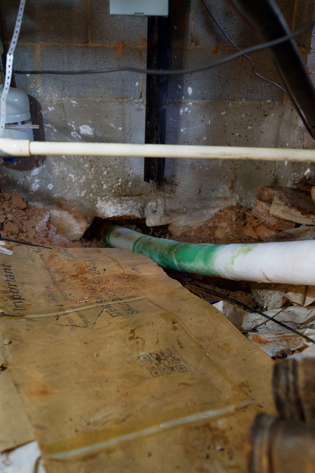 LiningWorks technician working a pipe line through a basement wall access point.