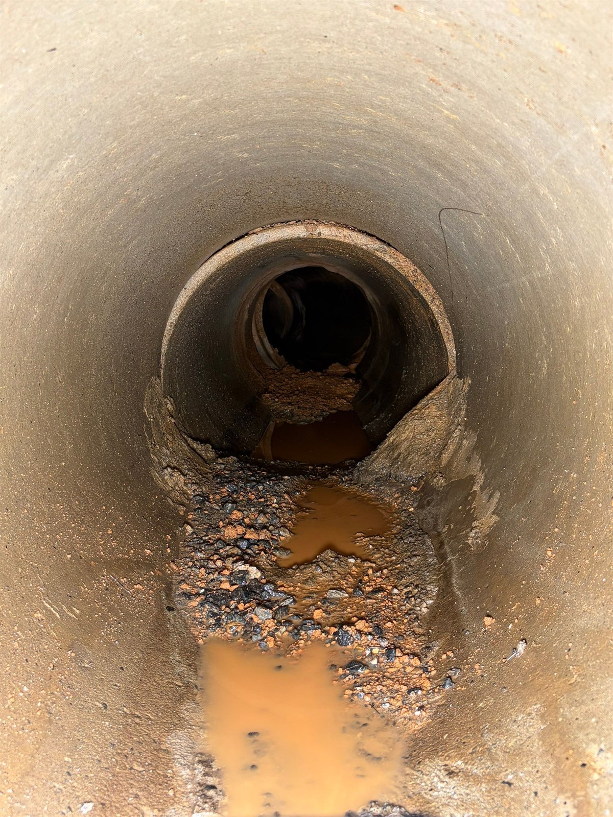 Interior of a drain line holding debris and standing water before it is flushed clear.