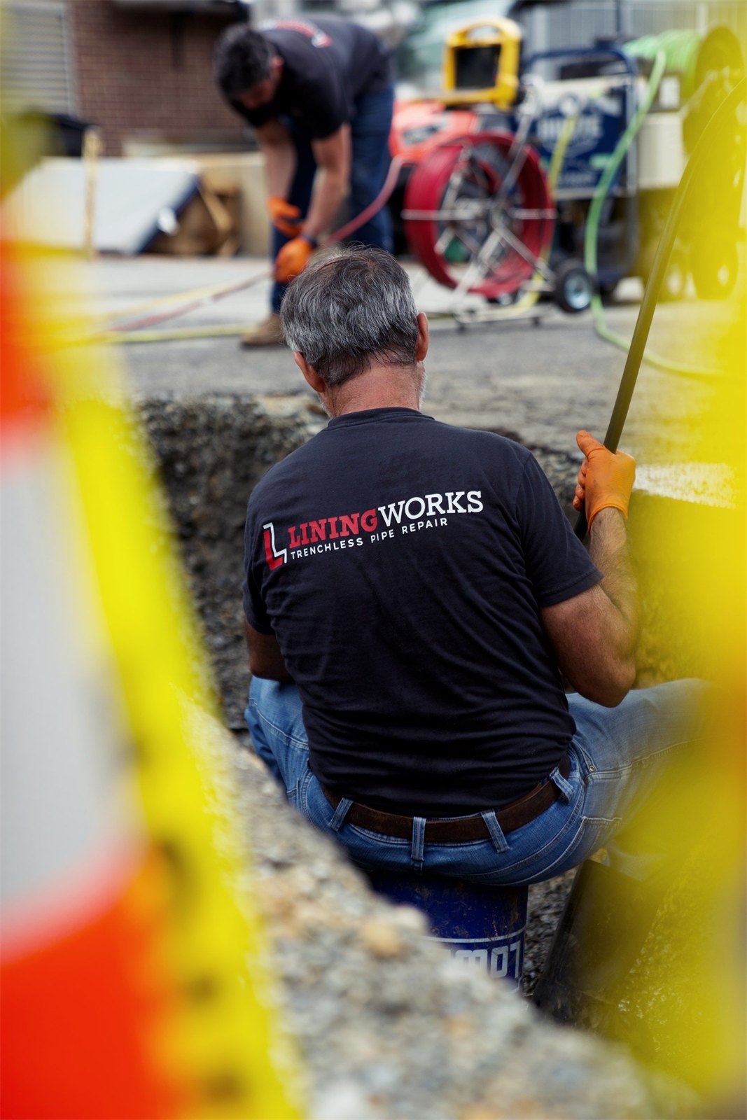 LiningWorks team members installing sewer lining equipment on a job site.
