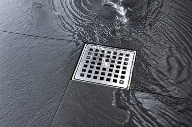 Water draining into a bathroom fixture, the everyday sign of a restricted drain line.