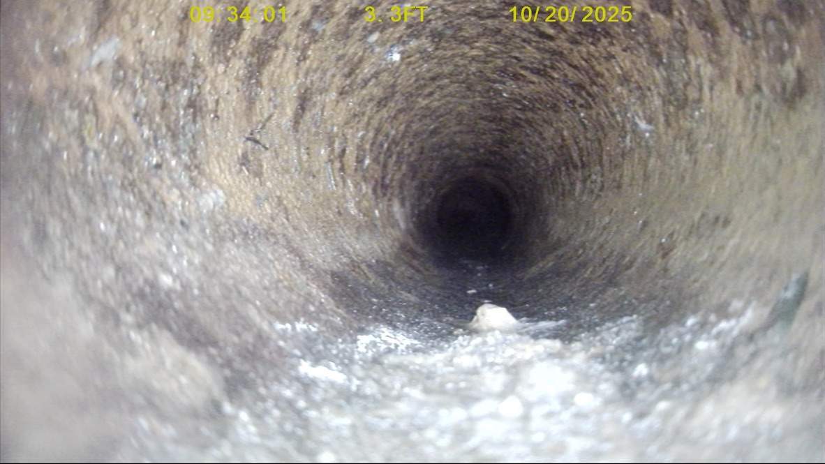 Measuring and recording a pipe defect during a sewer camera inspection.