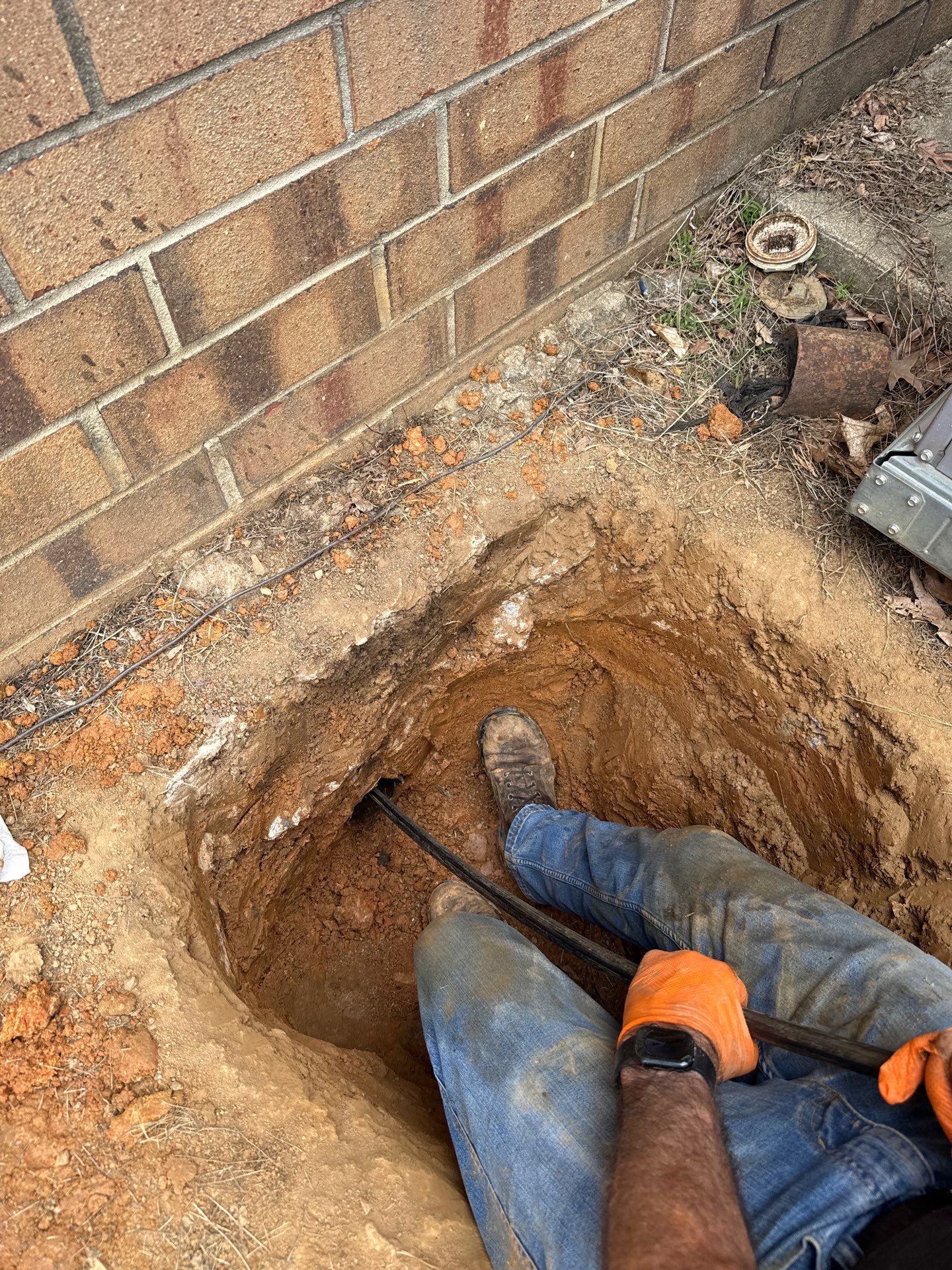 LiningWorks technician preparing a motorized auger during a sewer line snaking service call.