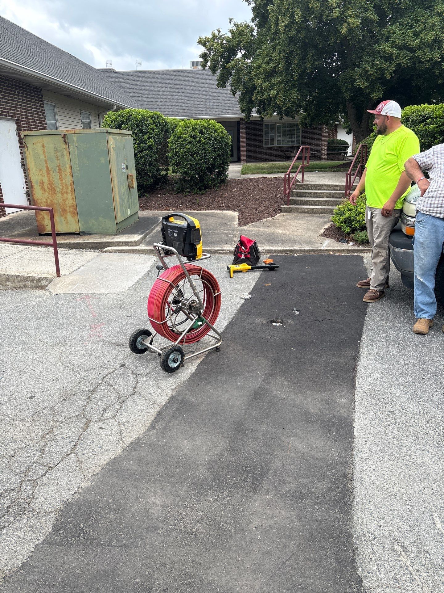 LiningWorks technician explaining sewer camera diagnostics footage to a homeowner before recommending a drain cleaning solution.