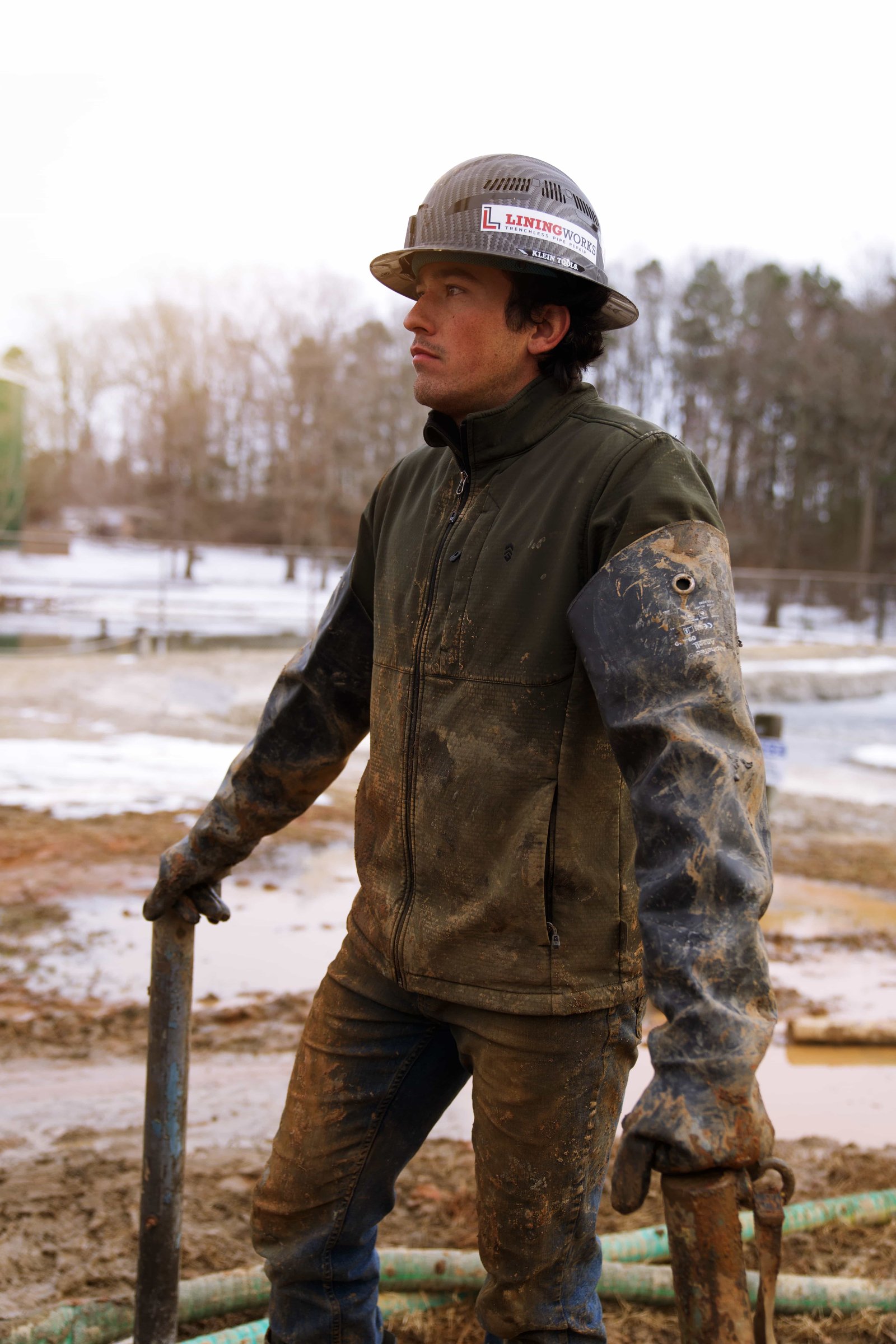 Jeremiah Helmeth, owner of LiningWorks, on a job site in a hard hat and LiningWorks branded gear.
