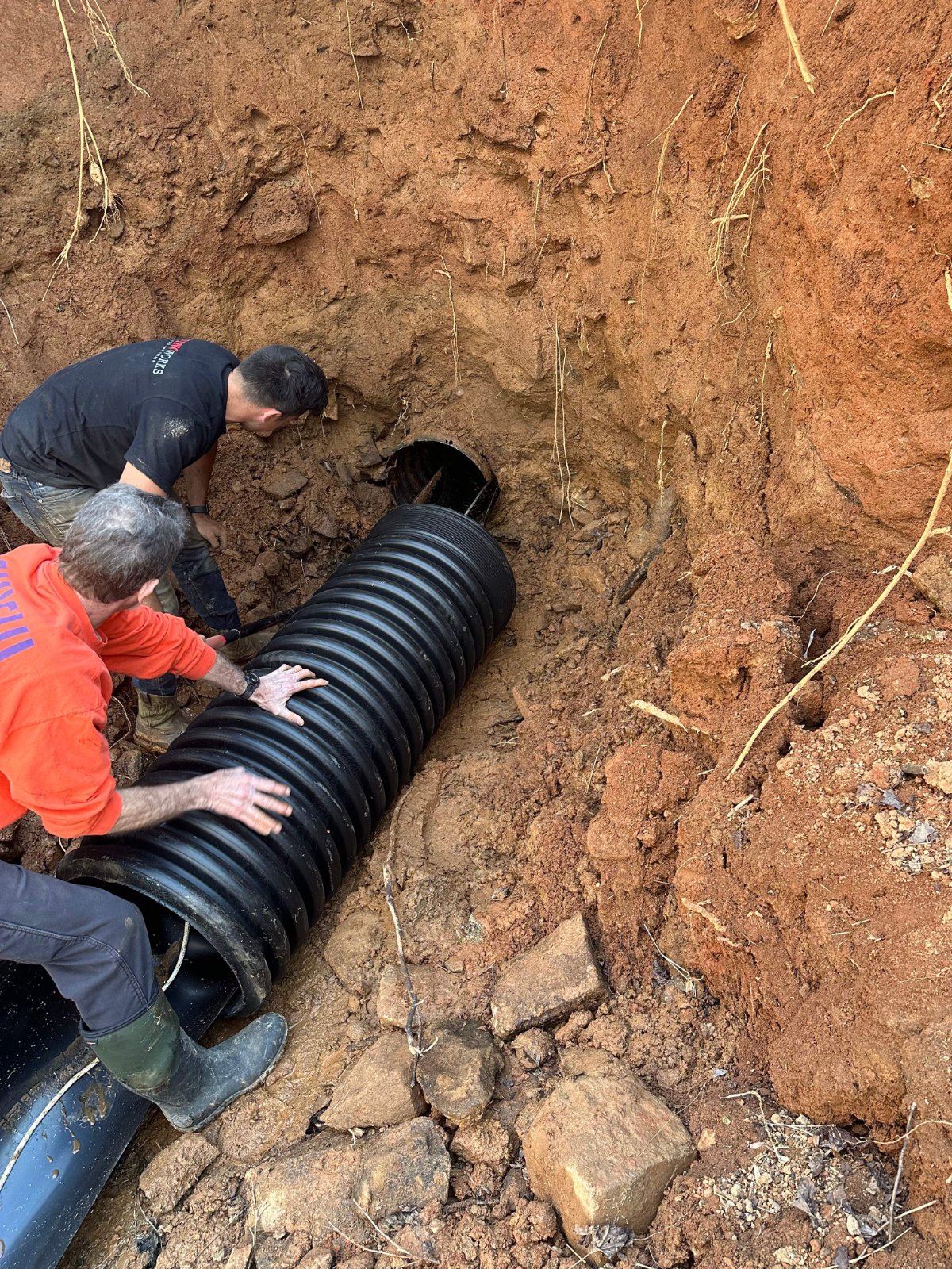 LiningWorks crew installing a new storm drain pipe in an excavated trench during rehabilitation.