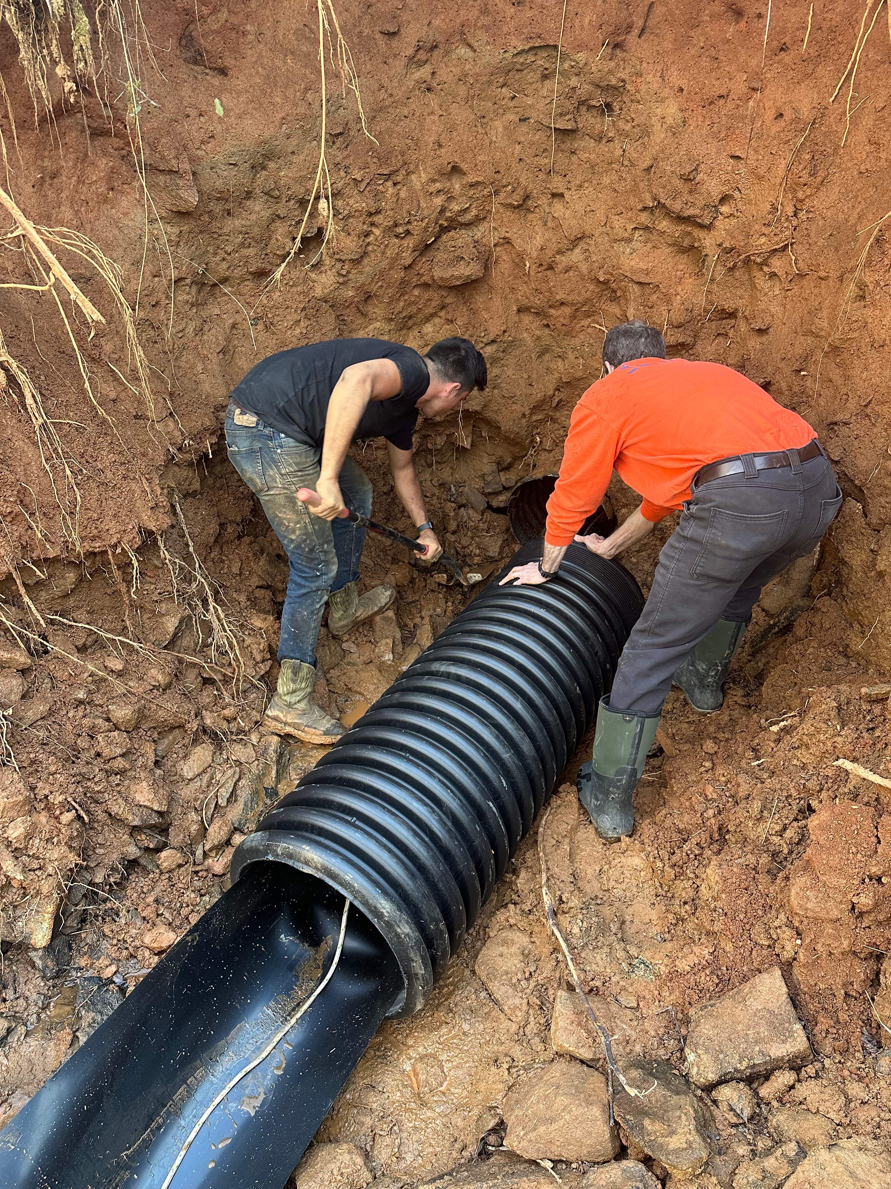 LiningWorks Trenchless Pipe Repair & Sewer Pipe Lining crew installing a corrugated drainage pipe in a trench in Wilkesboro