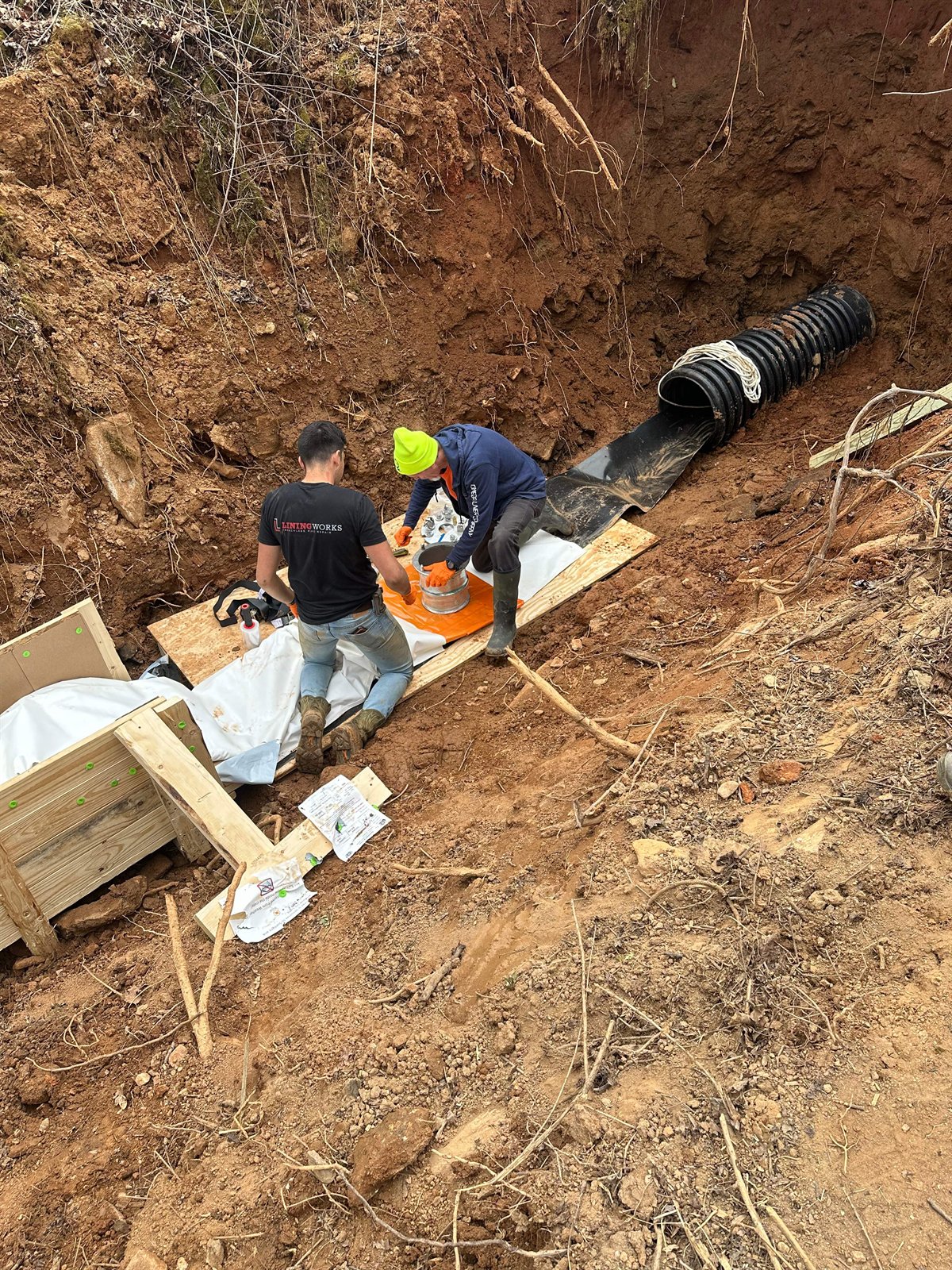 LiningWorks crew preparing a CIPP spot liner at a storm drain access point, with no full-run lining required.