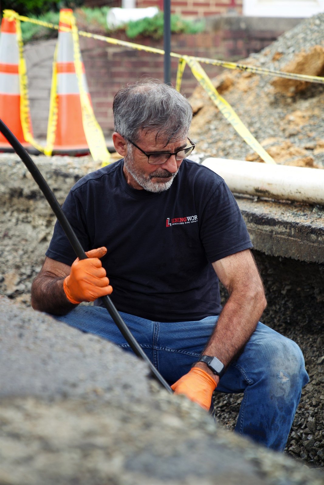LiningWorks technician inspecting the host pipe from an excavated trench before Trenchless Pipe Lining.