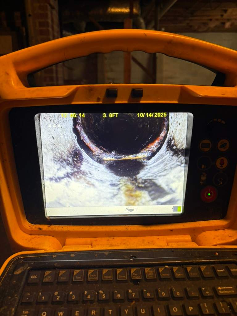 Sewer camera monitor showing a sagging sewer pipe section during a LiningWorks inspection.