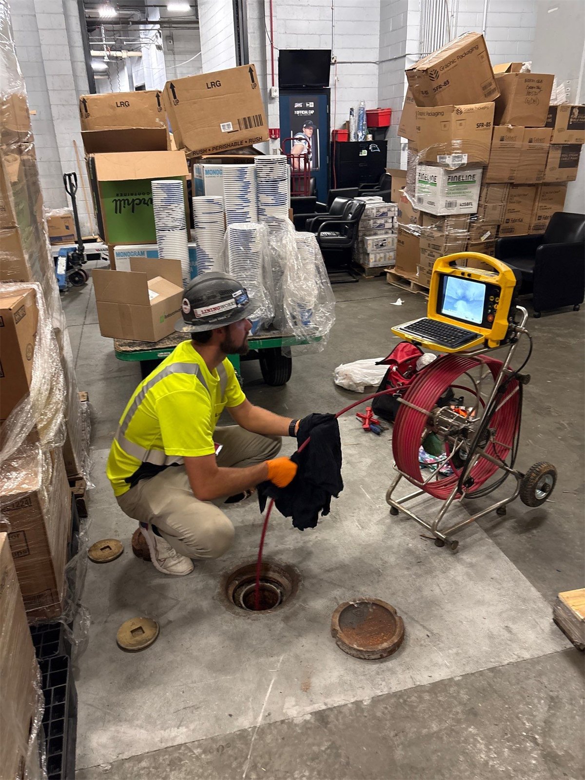 LiningWorks technician running a video pipe inspection at a floor drain to confirm descaling results.
